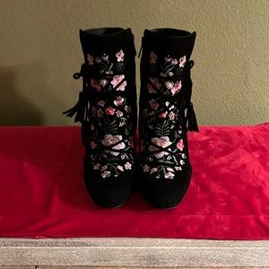 Black suede booties with embroidered flowers.